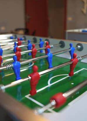 A close-up of a foosball table with red and blue players.