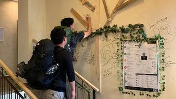 Una scala con travi in legno e un muro ricoperto di scritte e disegni a mano.