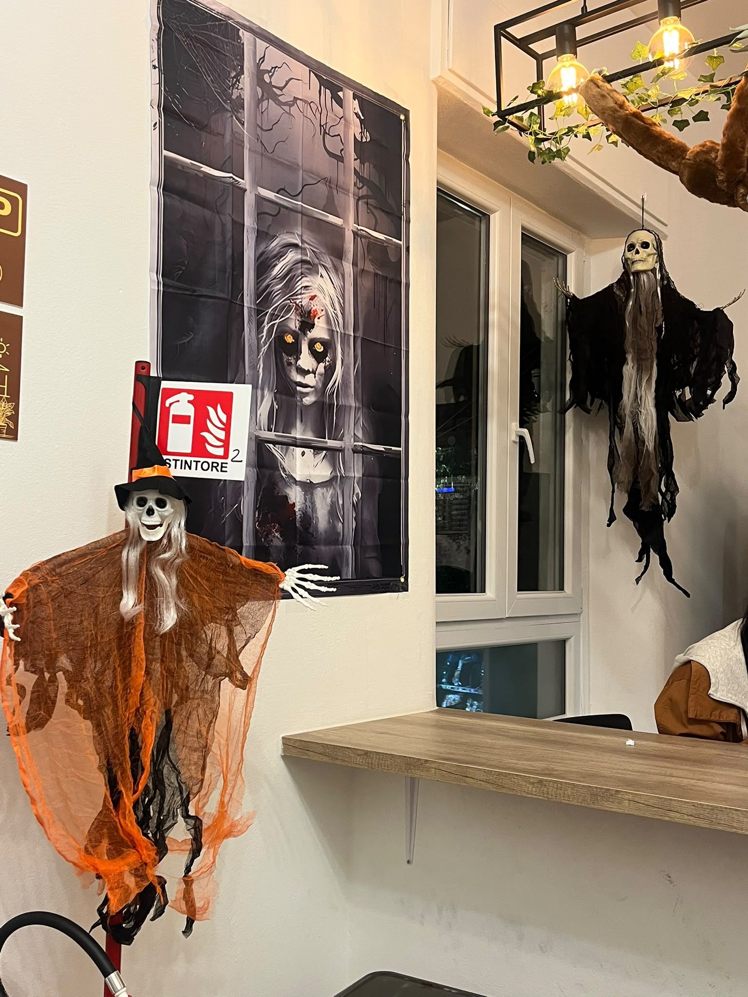 Une pièce décorée d’une affiche représentant un zombie, une silhouette de squelette et un panneau indiquant l’emplacement d’un extincteur.