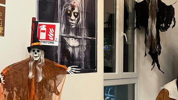 Une pièce décorée d’une affiche représentant un zombie, une silhouette de squelette et un panneau indiquant l’emplacement d’un extincteur.