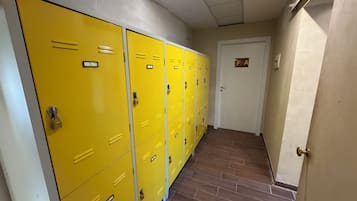 A hallway with yellow lockers and a door marked with an 'A' sign.