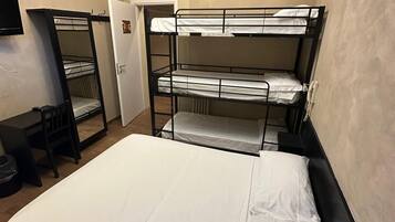 A bunk bed room with a desk and chair, an air conditioning unit, and a door with a sign.