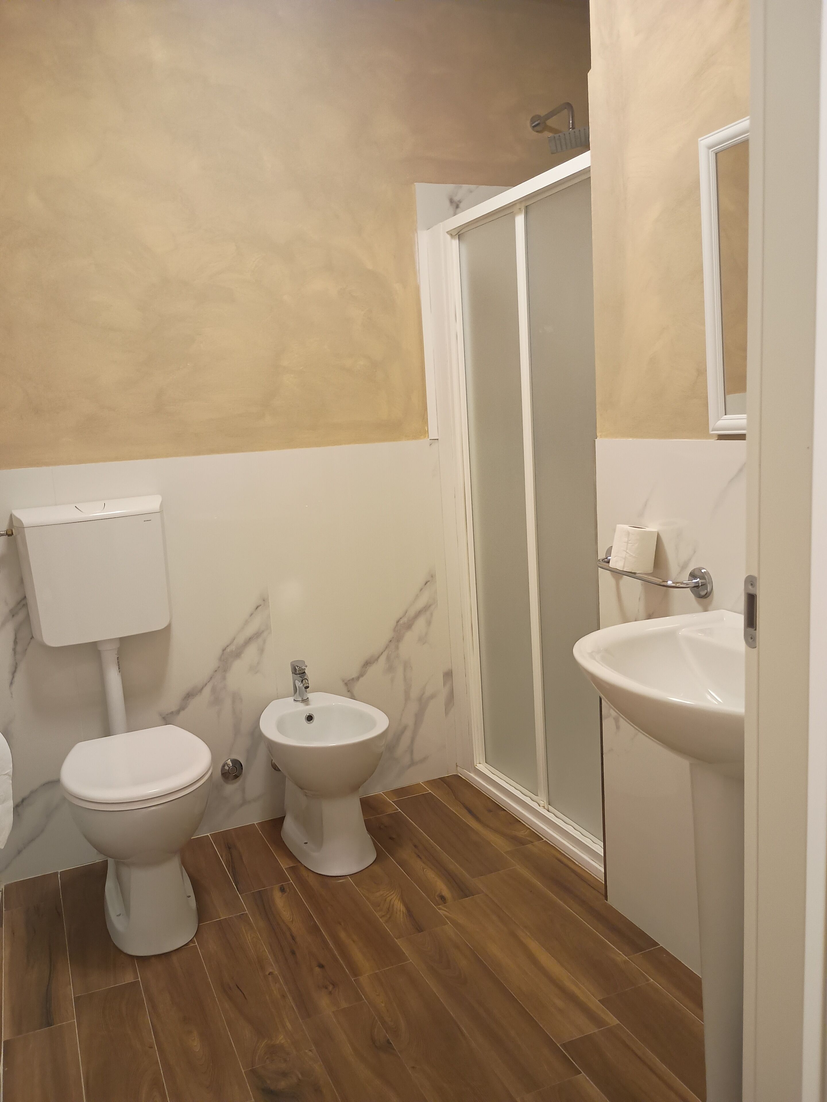 A bathroom with a toilet, bidet, and sink.