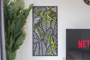 A wall with a decorative panel featuring a leaf pattern and a plant. - 10 minute walk to Anfield | FREE Parking | Sleeps 4 | Contractor Friendly | WIFI (Liverpool)