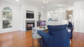 A spacious living room with a fireplace, a television, and a blue sofa. - WINTER RENTER AMENITIES INCLUDED 4 bdr Elevator 8500 monthly Seabrook Charleston (Seabrook Island)