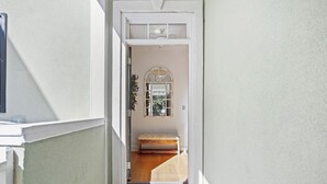 A hallway leading to a room with a bench, a door with a doormat, and a window with a view. - WINTER RENTER AMENITIES INCLUDED 4 bdr Elevator 8500 monthly Seabrook Charleston (Seabrook Island)
