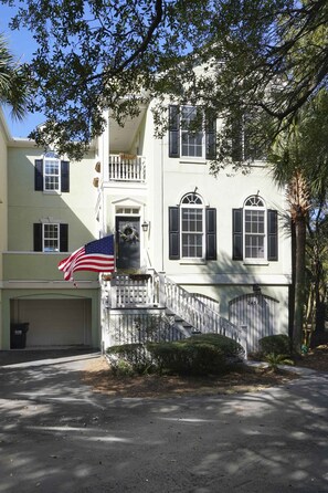 Ein zweistöckiges Haus mit Veranda, Garage und amerikanischer Flagge.