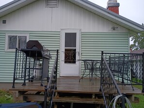 A house with a front porch, a grill, and a metal fence.