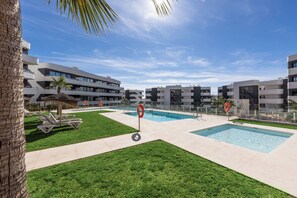 A modern pool area with multiple swimming pools, lounge chairs, and a palm tree. - Alicia | Garden & Pool View, Fuengirola (Fuengirola)
