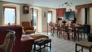 Ein geräumiges Wohnzimmer mit einem roten Sofa, einem Holzesstisch und einem Fernseher.