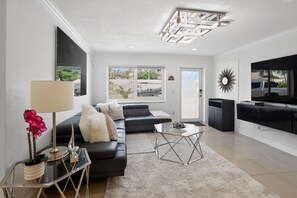 Ein modernes Wohnzimmer mit einer Couch, einem Couchtisch und einem Fernseher.