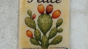 Une enseigne portant l’inscription « Casa Felice » et une illustration de cactus.