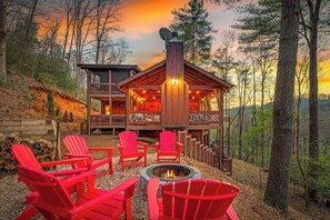 Eine Hütte mit Terrasse, Sitzgelegenheiten im Freien und einer Feuerstelle.