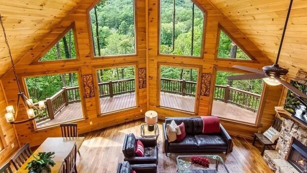 A wooden cabin with large windows, a fireplace, and a deck. - Grounding Lodge | Sauna + Cold Plunge + Hot Tub (Blue Ridge)