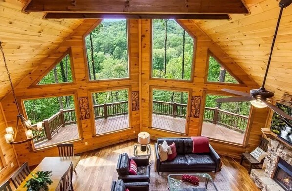 Eine Holzhütte mit großen Fenstern, einem Kamin und einer Terrasse.