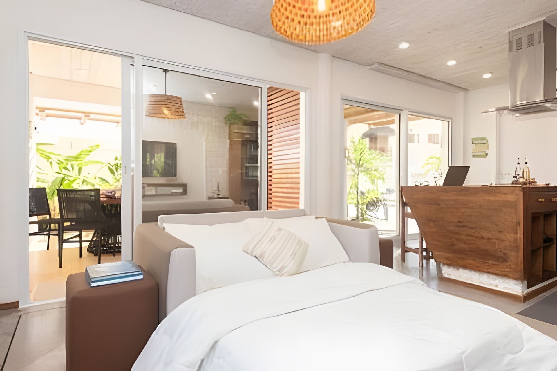 Una habitación de hotel moderna con una cama, un escritorio y vistas al exterior.