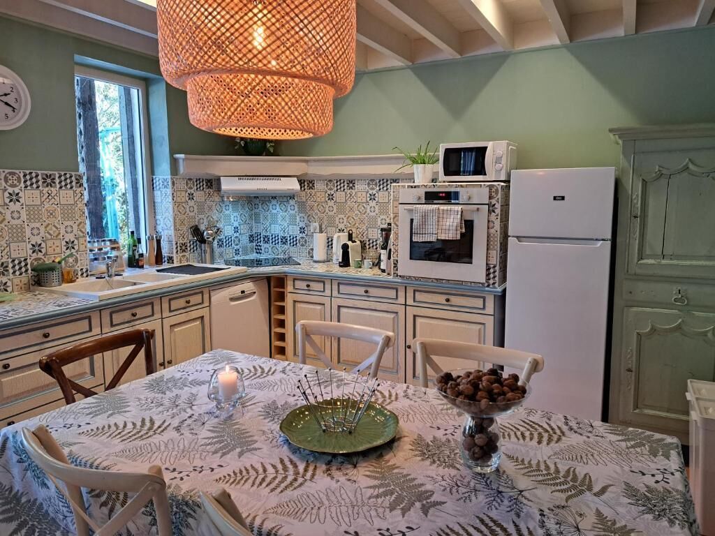 Una cocina con baldosas estampadas, una mesa de comedor con una vela y un cuenco de fruta.