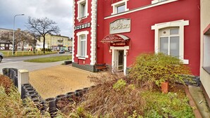 Un bâtiment rouge abritant une réception et portant une enseigne sur laquelle on peut lire « DOMA POMORSKI ».