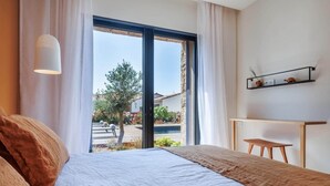 Een slaapkamer met een bed, een bureau en uitzicht op de omgeving.