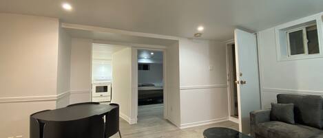 A modern living room with a dining area, a sofa, and a kitchen in the background.