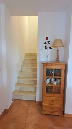 A staircase leading to a higher floor, a wooden cabinet with glass doors, and a lamp on top. - House 1min steps from the beach and nature, with AC, internet. (Santa Pola)