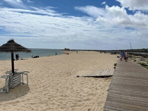 Pantai di sekitar, payung pantai, dan handuk pantai