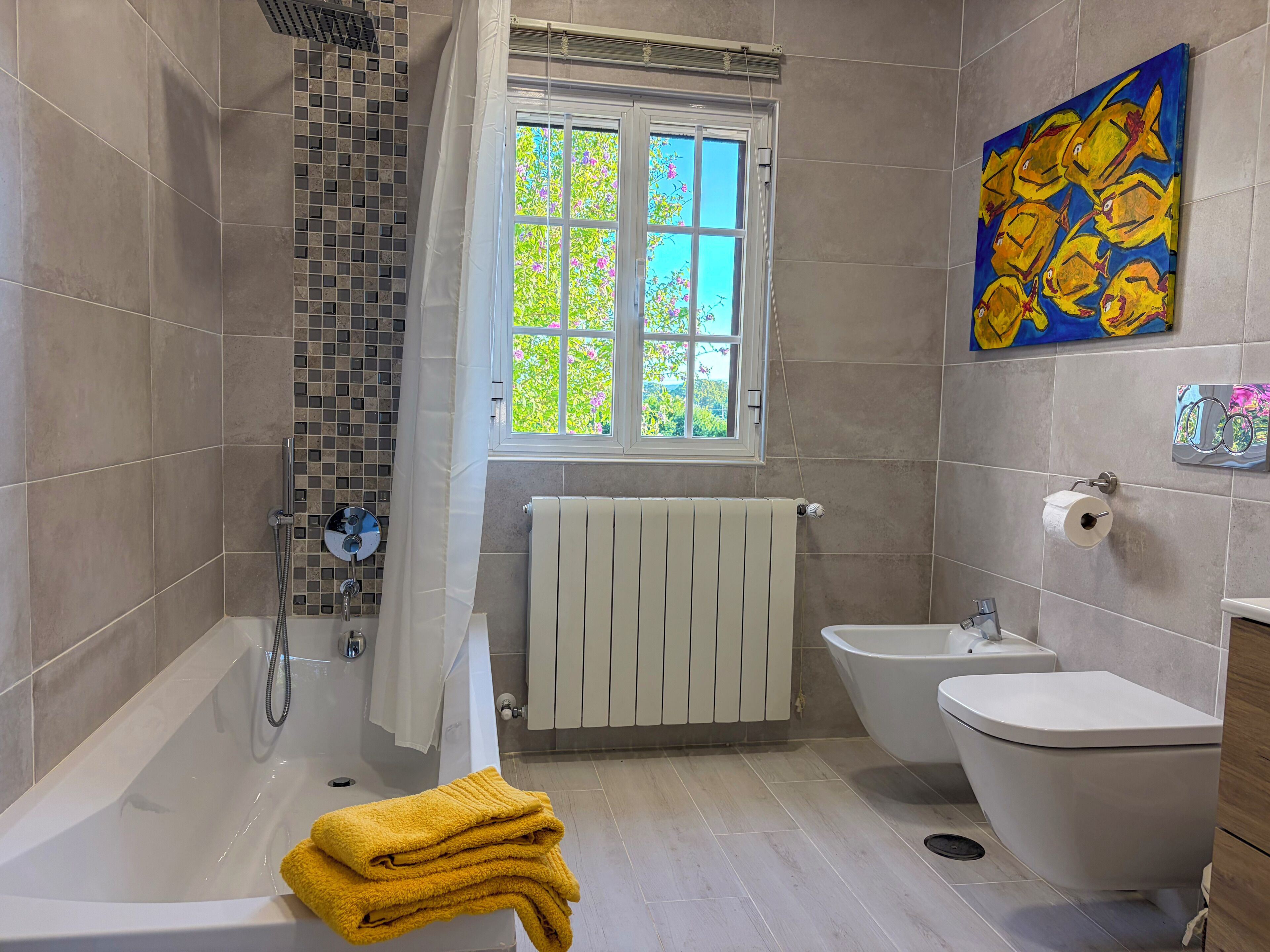 A bathroom with a bathtub, a shower, a bidet, and a toilet.