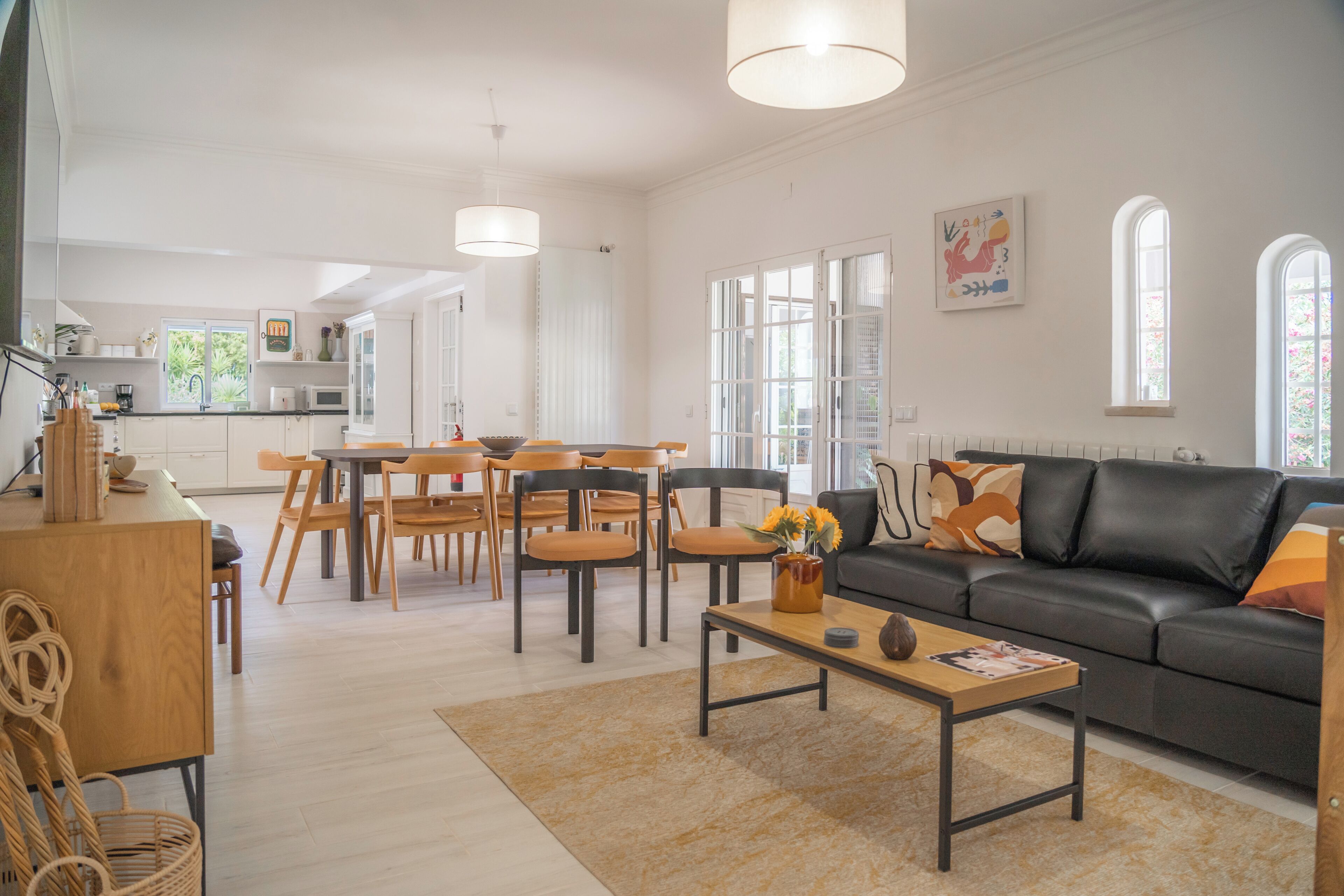 A spacious living area with a sofa, coffee table, and dining table.