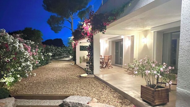 A well-lit outdoor area with a stone pathway leading to a covered patio with seating. - Modern, comfortable apartment located 200 meters from the beach and 1 km from shops (Roquebrune-sur-Argens)