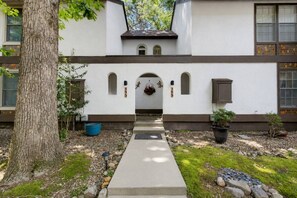 A building with a central entrance, a tree to the left, and a pathway leading to the entrance. - 189 Cordero Cottage Ln (Hot Springs)