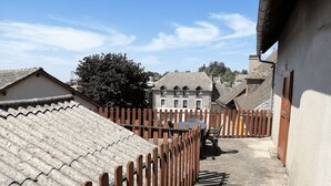 A narrow alleyway with a wooden fence, stone buildings, and a clear sky. - Cozy 2-bedroom apartment with a large balcony - Montsalvy (Montsalvy)