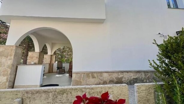 A modern building with a white facade, an arched entrance, and a satellite dish on the roof. - Villa Maryam (Agrigento)