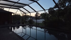 Un espace extérieur abrité comprenant un bassin décoratif, un coin salon et une vue sur le paysage environnant.