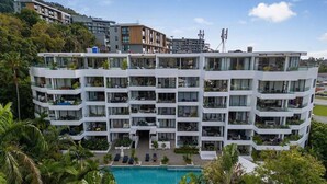 A multi-story hotel with balconies, a swimming pool, and lush greenery. - Best Sea Views Walk Surin Beach- Sunsuri C297 (Choeng Thale)