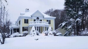 A large two-story house with a balcony, surrounded by snow-covered trees and bushes. - Oceanview Classic Maine Cottage within 1 minute. (York)