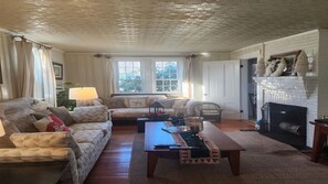 Ein Wohnzimmer mit Kamin, zwei Sofas, einem Couchtisch und einer Lampe.