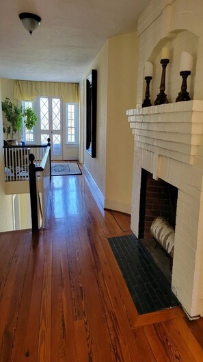 A spacious room with hardwood flooring, a fireplace, and a staircase leading to an upper level. - Oceanview Classic Maine Cottage within 1 minute. (York)