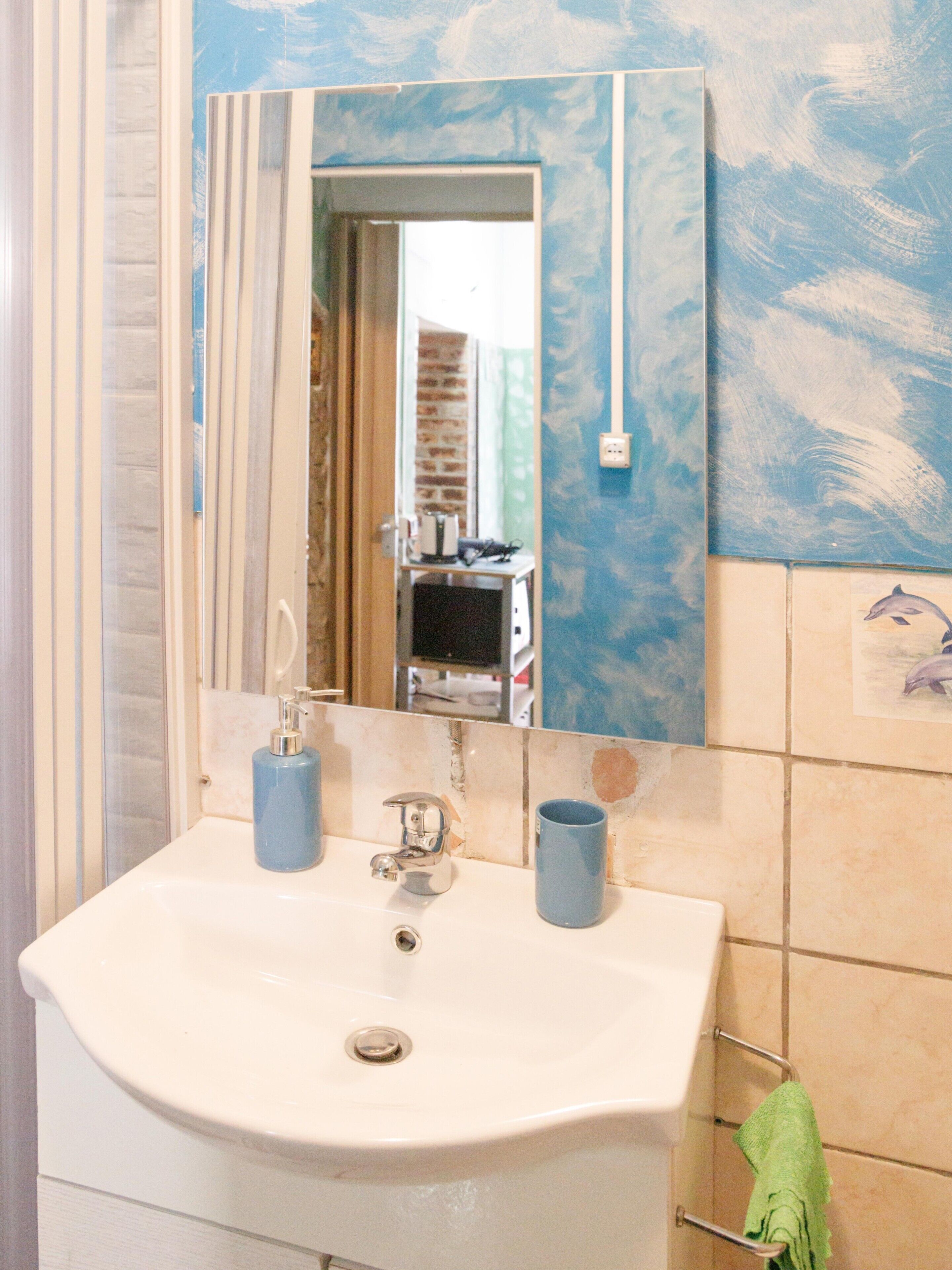 A bathroom with a sink, mirror, and a towel rack.