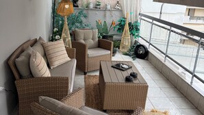 A balcony with wicker furniture, a table, and decorative plants. - RHODESIA guest house
Sea view apartment
Pet friendly
2’  beach (Chalkida)