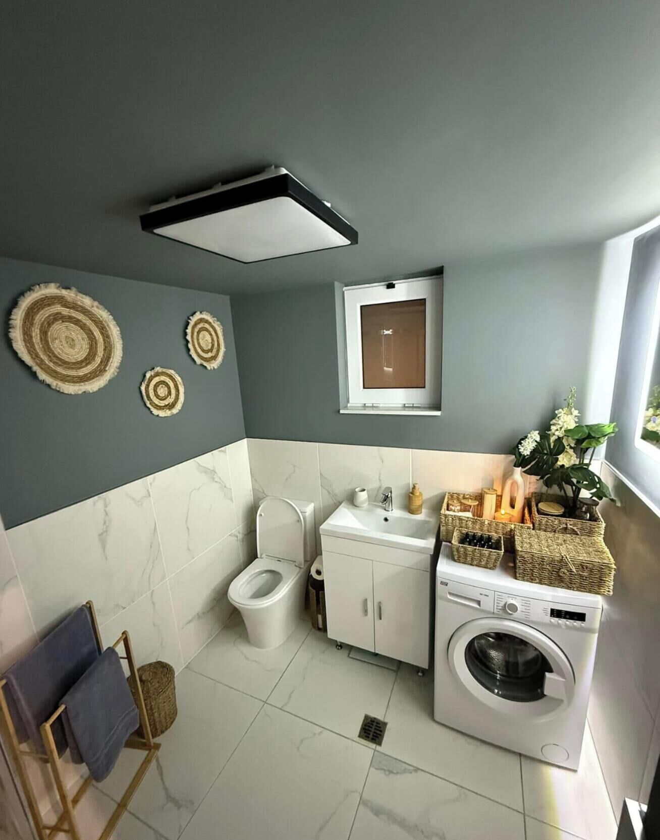 Un baño moderno con inodoro, lavabo y lavadora.