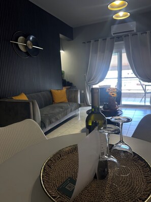 Ein modernes Wohnzimmer mit Sofa, Esstisch und Blick ins Freie.