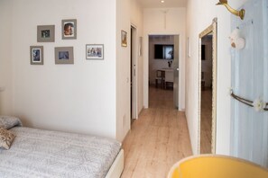 Ein Schlafzimmer mit einem Bett, einem Sessel und einem Flur, der zu einem Badezimmer führt.