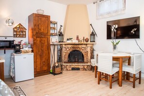 Ein gemütliches Wohnzimmer mit Kamin, einer Holzschrank und einem Essbereich.