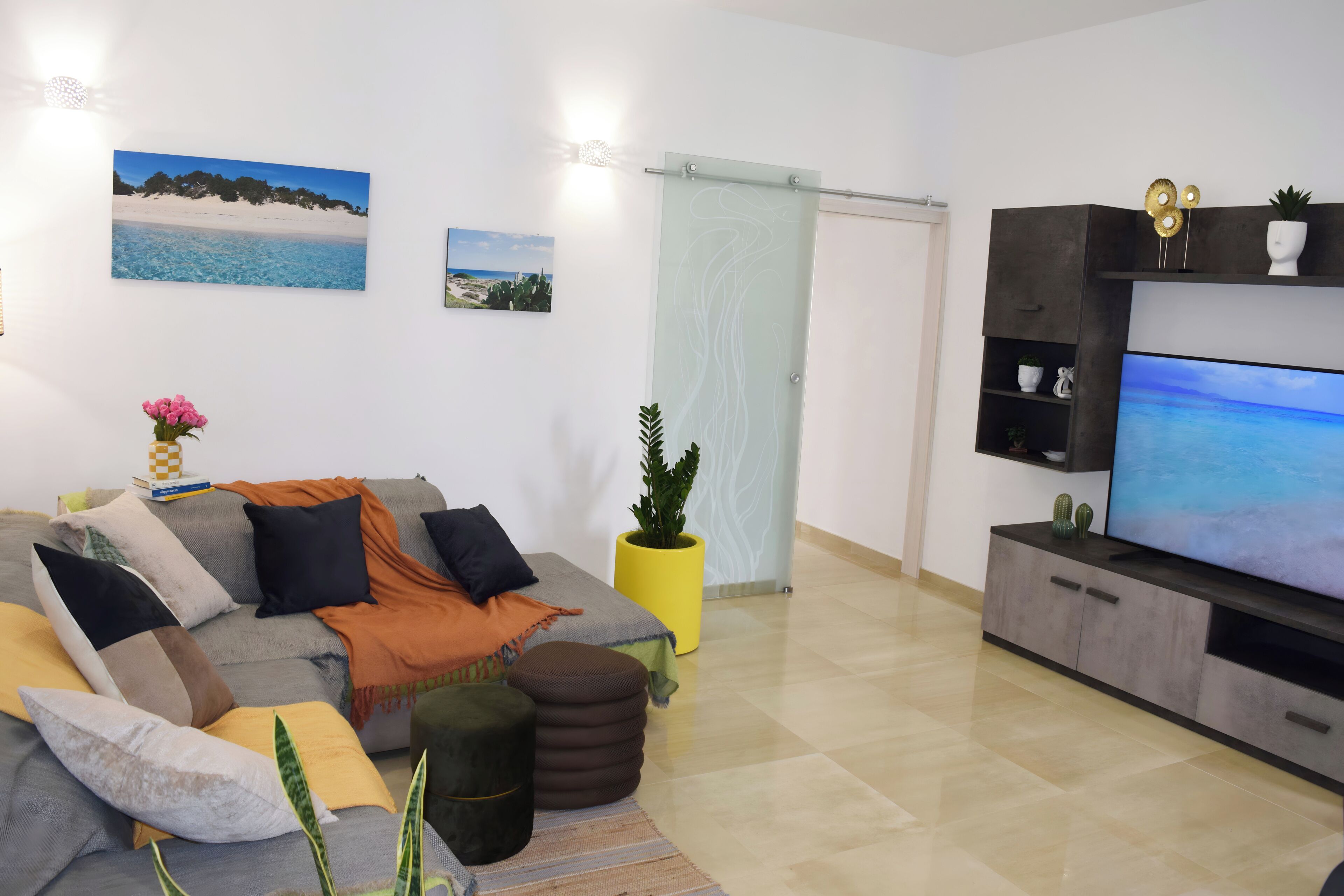 Una sala de estar con un sofá, televisor y objetos decorativos.