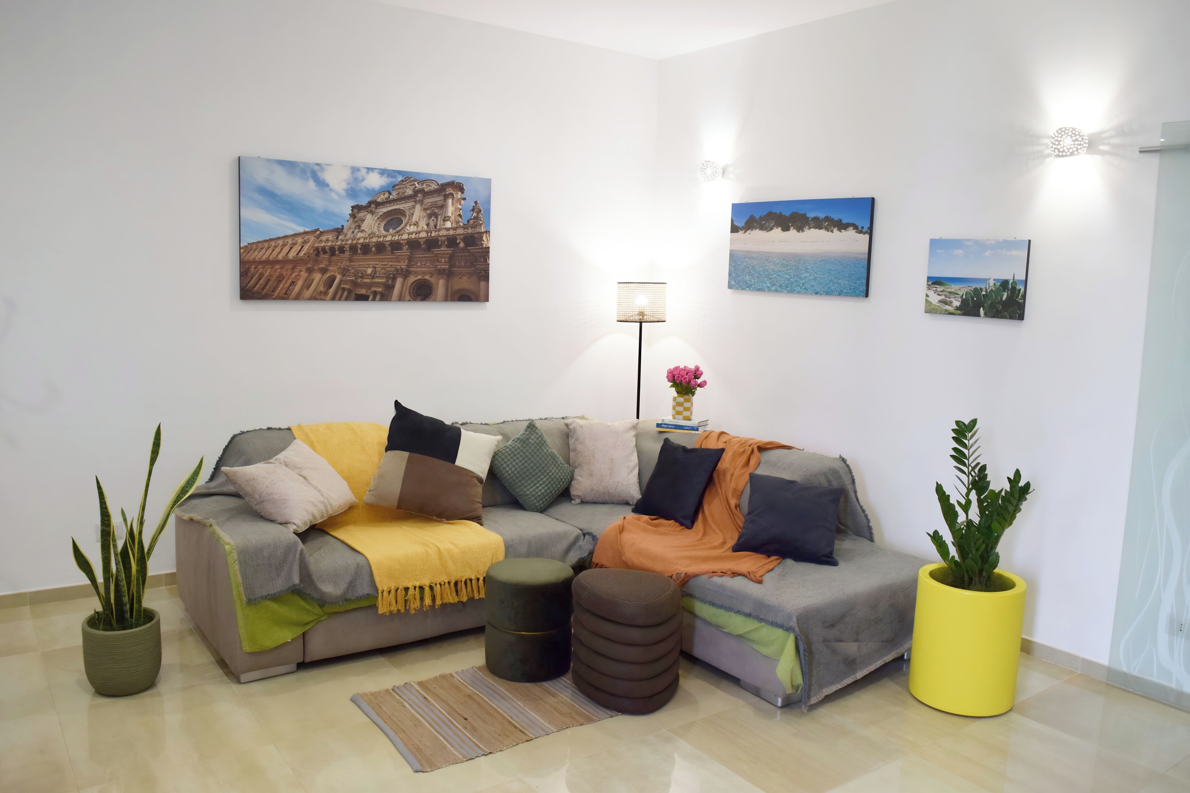 Un salon avec un canapé, une table basse, un lampadaire et une plante en pot.