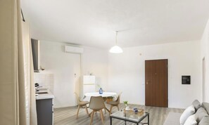 Una sala moderna con comedor, cocina y una puerta de madera.