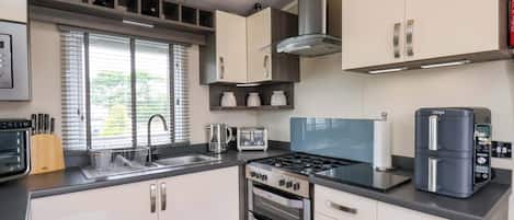 A modern kitchen with stainless steel appliances, a gas stove, a built-in oven, and a coffee maker.