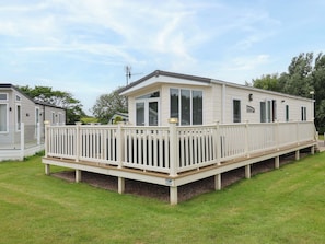 A mobile home with a deck, large windows, and a satellite dish. - Finch 66 (Scarborough)