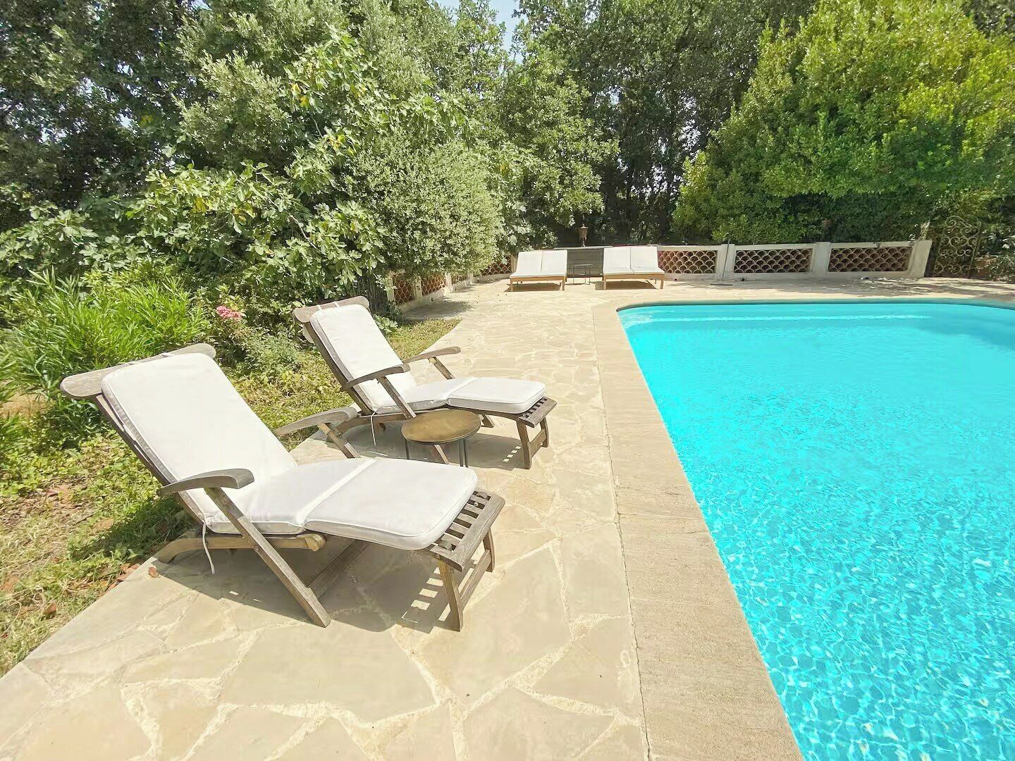 Ein Schwimmbecken mit Liegestühlen und einer Steinbepflasterung.