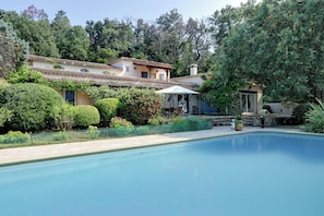 Ein Schwimmbad mit einem Haus im Hintergrund.